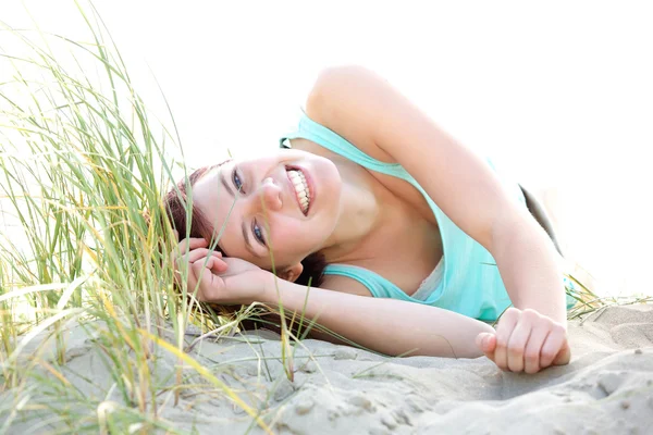 Jovem mulher despreocupada deitada na praia — Fotografia de Stock