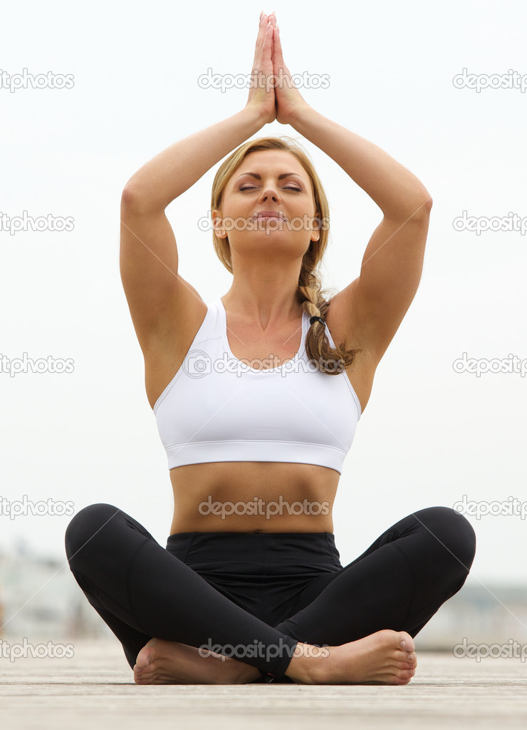 Young woman sitting in yoga pose outdoors