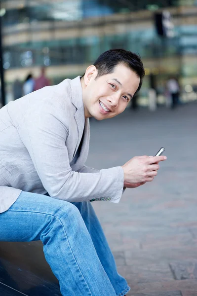 Красивый азиатский мужчина с мобильным телефоном — стоковое фото