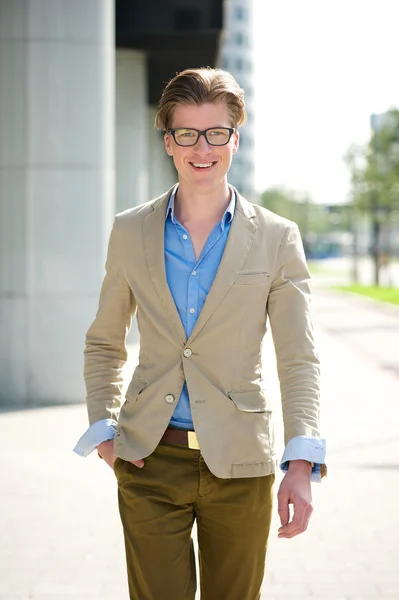 Lachende jonge man met bril wandelen — Stockfoto