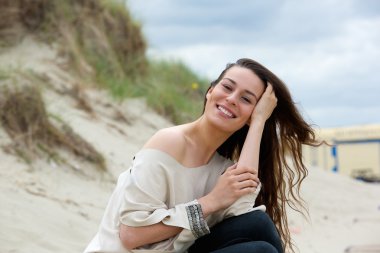 Dışarıda gülümseyen saçı olan bir kadın.