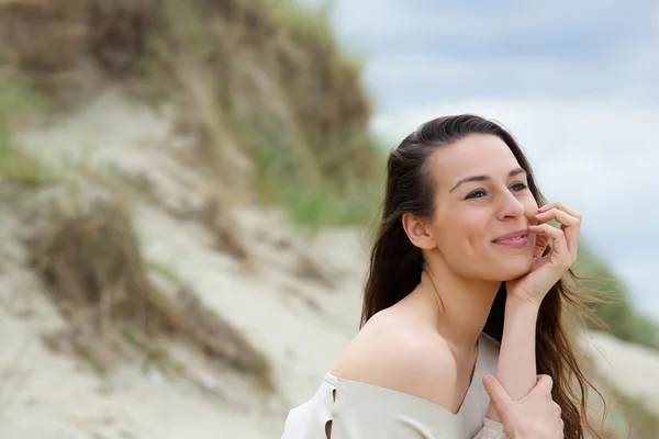 Mladá žena sedí venku myšlení — Stock fotografie