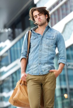 cool adam dışında deri çanta ile poz