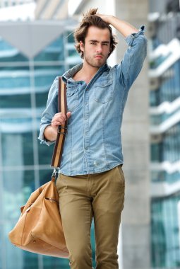 erkek model açık havada seyahat çantası ile poz
