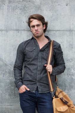 erkek model deri seyahat çantası ile poz 