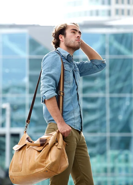 Modelo de moda masculina posando com saco de couro — Fotografia de Stock