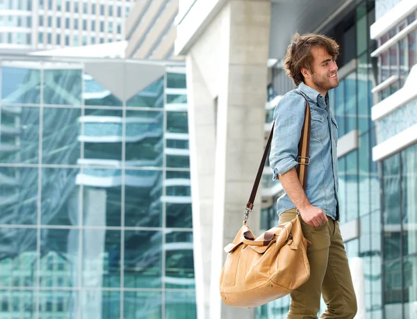 Joven de moda sonriendo con la bolsa de viaje —  Fotos de Stock