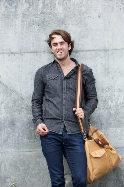 Joven hombre de moda sonriendo bolsa de ingenio — Foto de Stock