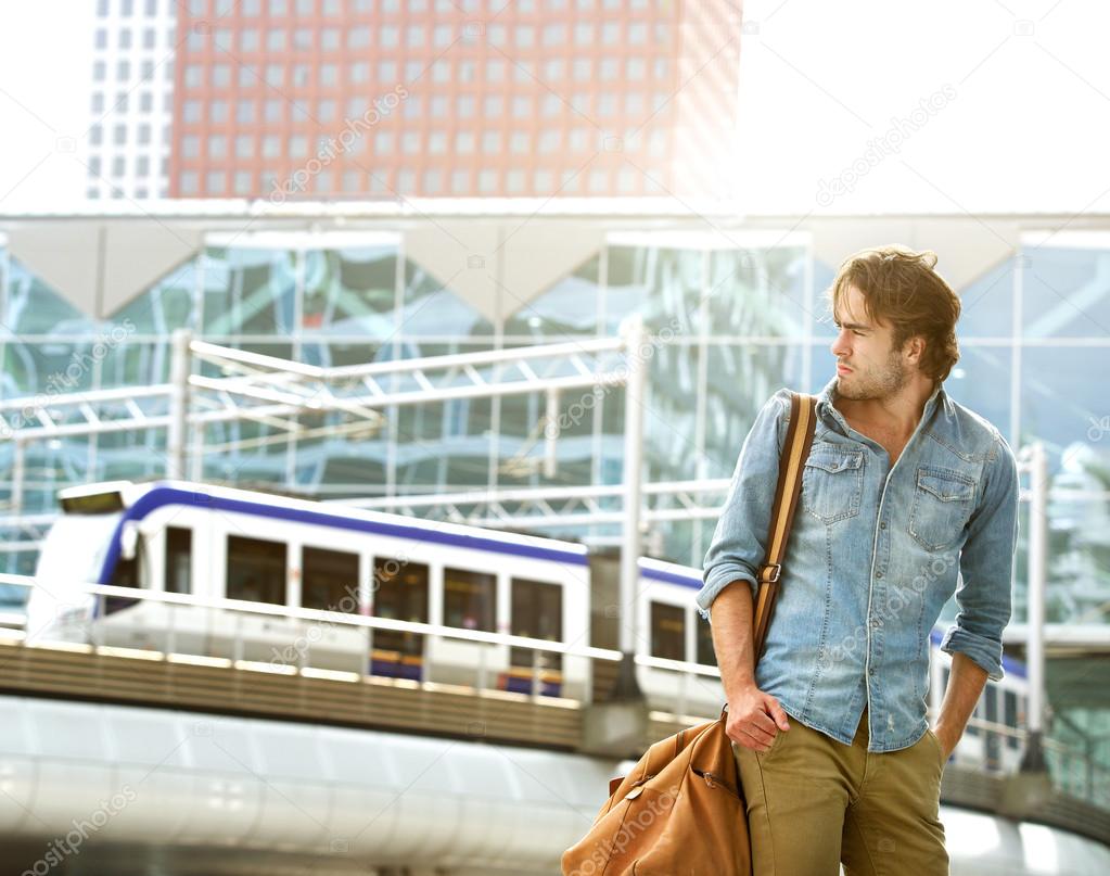 Fashionable young man traveling with bag