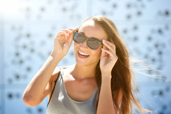 Zorgeloos jonge vrouw die lacht met zonnebril Stockfoto