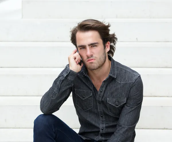 Cool gars assis à l'extérieur avec téléphone mobile — Photo