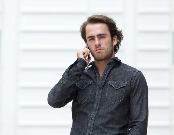 Çekici bir genç adam cep telefonunuzun konuşma — Stok fotoğraf