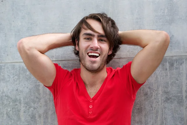 Joven riendo con la mano en el pelo — Foto de Stock