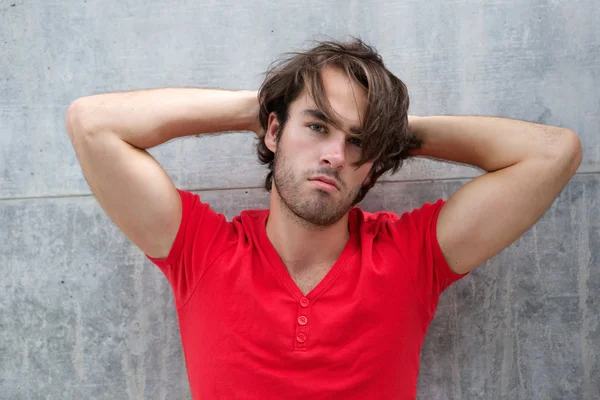 Bello giovane uomo in posa con mano nei capelli — Foto Stock