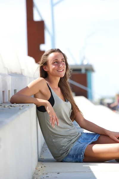 Young woman sitting outside on steps — Stock Photo, Image