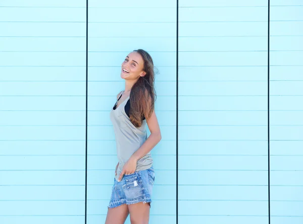 Unga kvinnan skrattar mot blå bakgrund — Stockfoto