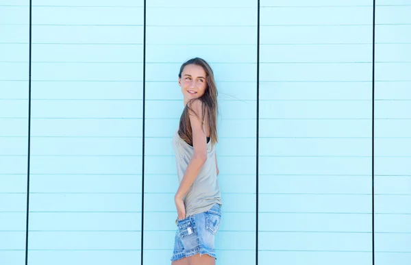Ung kvinna poserar mot blå bakgrund — Stockfoto