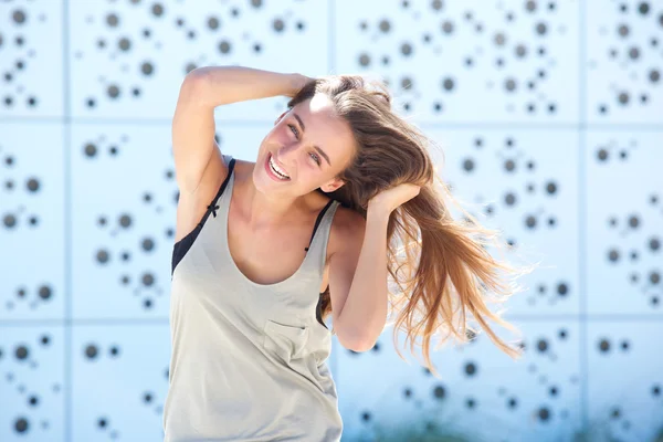 Jeune femme riant avec la main dans les cheveux — Photo