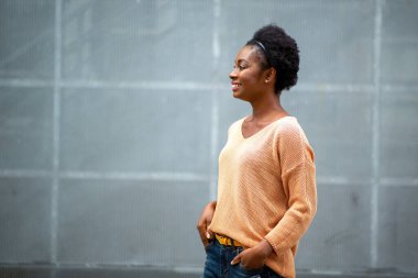 Side portrait smiling young black woman against gray background