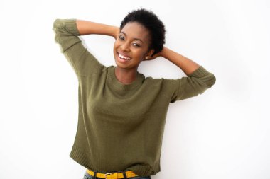 Portrait happy smiling young African American woman with hands behind head by isolated white background