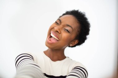 Close up portrait young black cheerful woman taking selfie by isolated white background 