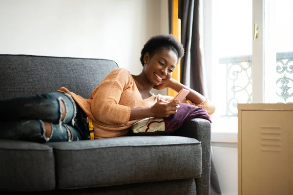 Portrait Beautiful Young Black Woman Relaxing Sofa Mobile Phone — Stockfoto