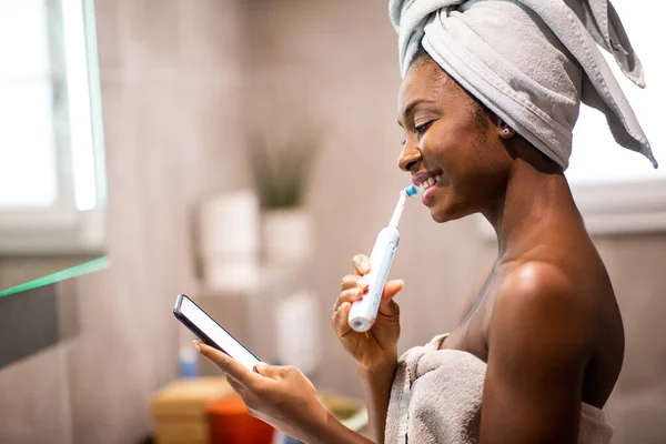 Side Portrait Young Black Woman Brushing Teeth Looking Mobile Phone — Stock Photo, Image