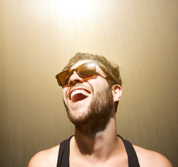 Joyeux jeune homme souriant avec des lunettes de soleil — Photo