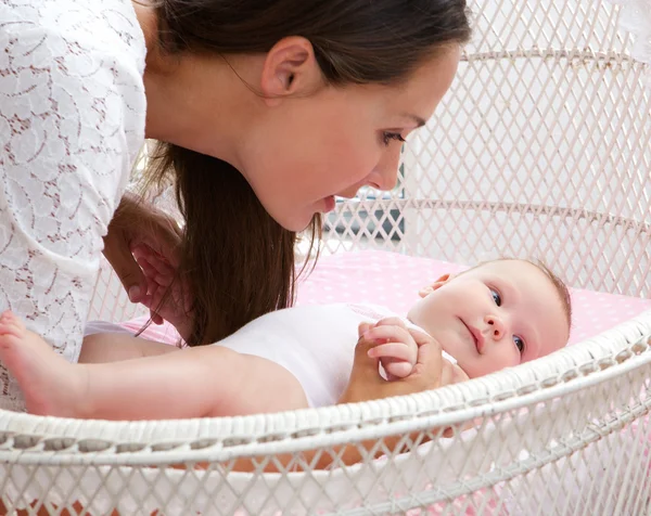 Attraktiv kvinna med baby i barnsäng — Stockfoto