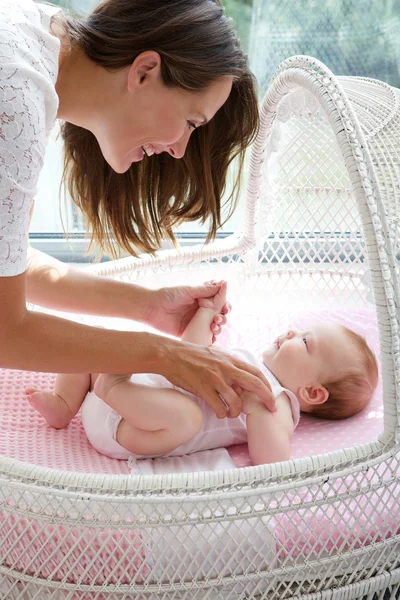 Bella donna sorridente con neonato in culla — Foto Stock