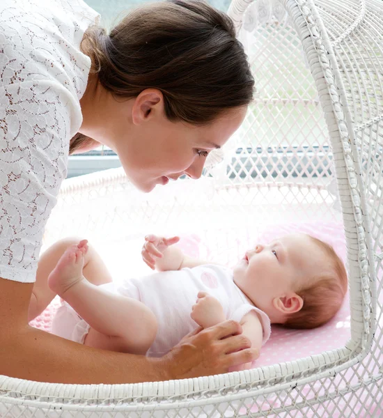 Mulher bonita olhando para o bebê na cama — Fotografia de Stock