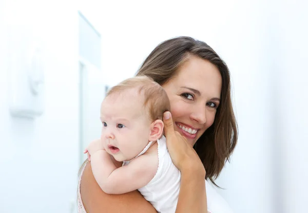 Mor leende med barnet hemma — Stockfoto