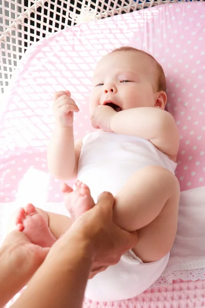 Weibliche Hände, die süße Babyfüße halten — Stockfoto