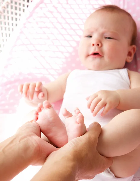 Madre in possesso di piedi bambino carino Foto Stock Royalty Free