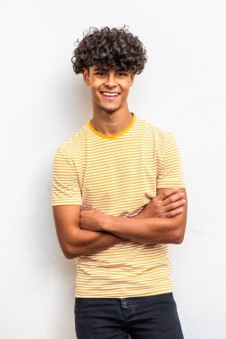 Portrait cool young north African man smiling with arms crossed 