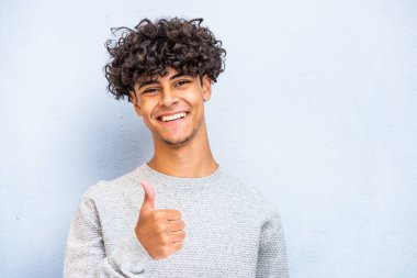 Close up portrait smiling young man with thumbs up hand sign
