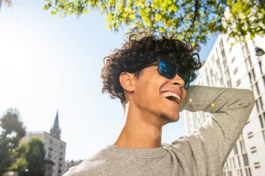 Close up portrait happy young man laughing with sunglasses outside