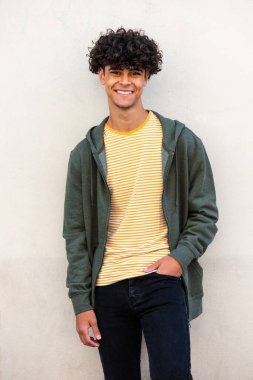 Portrait smiling young man posing by white wall