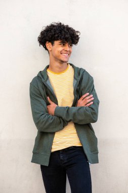 Portrait smiling cool young guy with arms crossed looking away