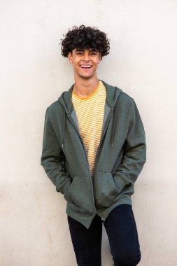 Portrait young North African man smiling by white wall