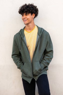 Portrait cool young male model smiling and posing by white wall