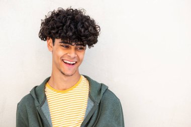 Close up portrait smiling young man laughing glancing away by white background 