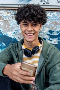 Close up portrait happy young smiling man holding mobile phone 