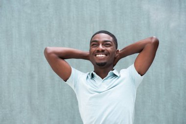 Portrait happy young black man relaxing with hands behind head