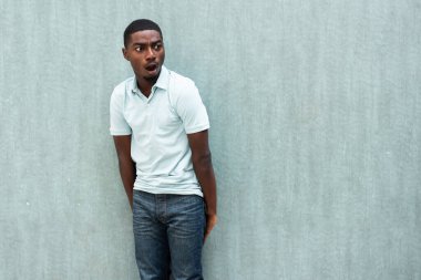 Portrait surprised young black man with mouth open looking away