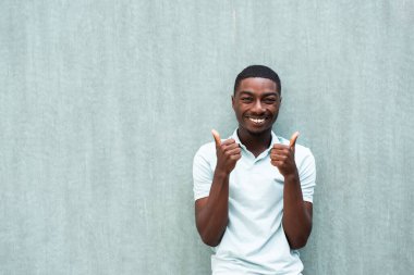Portrait smiling young African American man with thumbs up hand sign