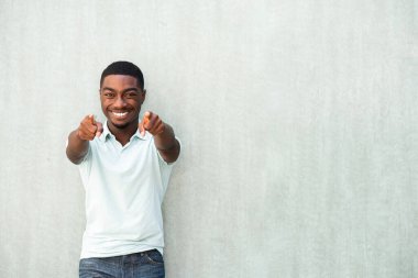 Portrait confident young African American man smiling and pointing fingers