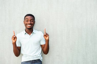 Portrait confident smiling young man pointing fingers up