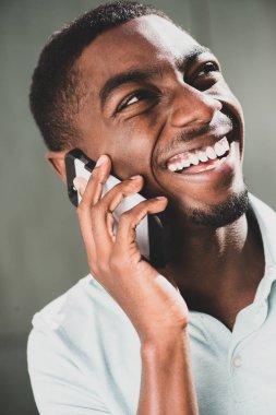 Close up portrait smiling young african American man talking with mobile phone 