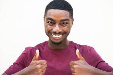 Close up portrait smiling young african American man with thumbs up hand sign by white background 